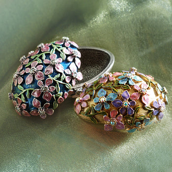 Enamel Easter egg boxes in silver and gold. Forget me not flowers decorate the surface.